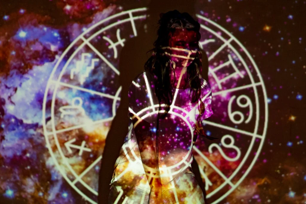 A mystical image of a woman enveloped in celestial projections and astrological symbols.
